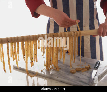 Sortir les bandes de pâtes de bois sec sur le rail. Banque D'Images