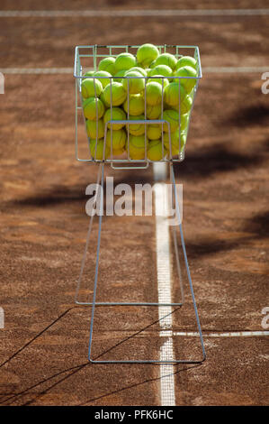 Heap de balles de tennis en panier métal sur terre battue Banque D'Images