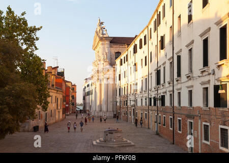 Campo dei Gesuiti et Chiesa dei Gesuiti, Cannaregio, Venise, Vénétie, Italie au coucher du soleil avec des gens marchant à travers l'antique et pozzo ou bien. Été Banque D'Images