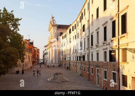 Campo dei Gesuiti et Chiesa dei Gesuiti, Cannaregio, Venise, Vénétie, Italie au coucher du soleil avec des gens marchant à travers l'antique et pozzo ou bien. Été Banque D'Images