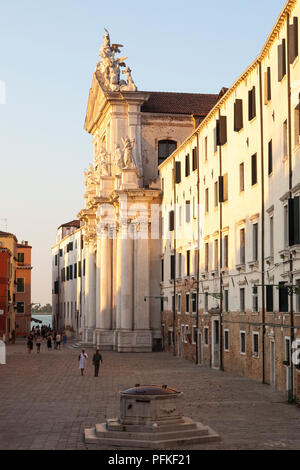 Campo dei Gesuiti et Chiesa dei Gesuiti, Cannaregio, Venise, Vénétie, Italie au coucher du soleil avec des gens marchant à travers l'antique et pozzo ou bien. Été Banque D'Images