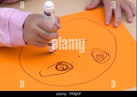 Girl's hand drawing visage avec feutre, close-up Banque D'Images