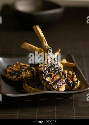 Sucettes, agneau agneau mariné et grillé côtelettes, sur la plaque brune Banque D'Images