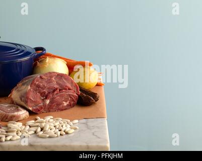 Ingrédients pour faire un ragoût, y compris les saucisses, la viande rouge, l'oignon, haricots, carottes, pommes de terre, et pot Banque D'Images