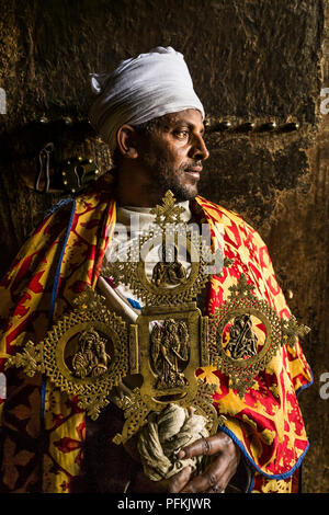 Un prêtre se tient dans l'embrasure d'Yemrehana Krestos Church, une église construite dans une grotte 15 1,6 km de Lalibela, Ethiopie, Afrique Banque D'Images