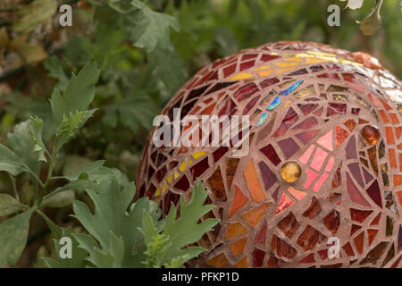 Close up of mosaic garden ball dans les tons d'oranges, de sphère rouge, orange et or réalisés à partir de carreaux de verre teinté, abstract design Banque D'Images