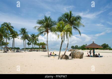 Sentosa, Singapour, de personnes et de palmiers sur la plage de Siloso de sable blanc Banque D'Images