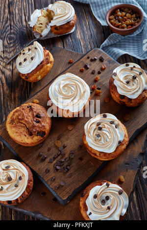 Le fromage cottage maison Cupcakes avec pastilles de chocolat et raisins décoré de roses de meringue, vertical Vue de dessus Banque D'Images