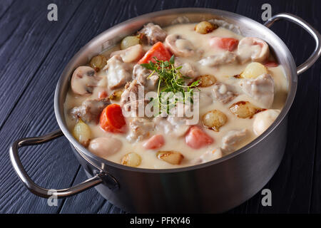 Ragoût de veau crémeux ou blanquette de veau - Morceaux de viande de veau à l'étuvée avec vitrage champignons oignons perles, et légumes en cocotte, recette française, vi Banque D'Images