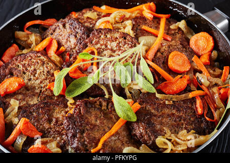 Crêpes du Foie frit avec carotte, oignon, herbes et épices dans une poêle, vue de dessus, close-up Banque D'Images