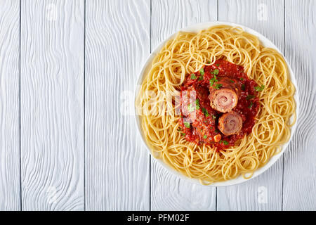 Braciole italien servi avec des spaghetti - Pavé de boeuf rouleaux remplis de tranches de prosciutto, fromage parmesan, râpé et le persil avec une sauce marinara sur w Banque D'Images