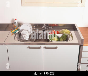 Wasing sur etendoir et légumes à salade séchage dans un évier de cuisine Banque D'Images