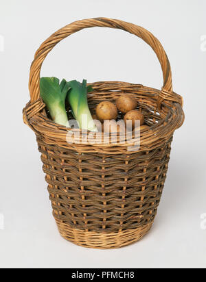 Poireaux et pommes de terre biologiques dans un panier en osier, close-up Banque D'Images