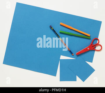 Les articles découpés dans un grand carré de carton bleu, petite paire de ciseaux en plastique, crayon et feutres de couleur. Banque D'Images