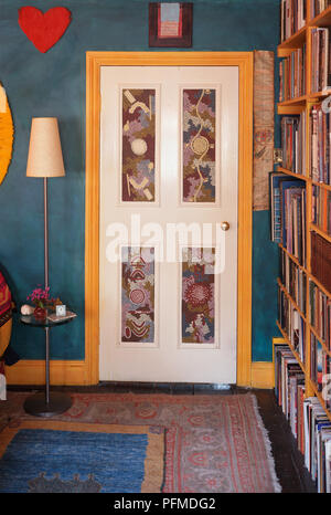 Porte Blanche, panneaux décorés de motifs, en grande chambre bleue, grand voyant derrière la porte, de hautes étagères de mur. Banque D'Images