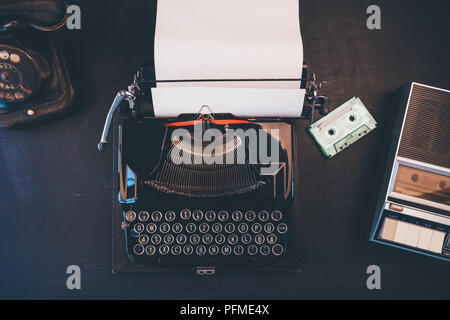 Vue de dessus de l'espace journaliste vintage avec téléphone, machine à écrire et lecteur de cassettes audio Banque D'Images