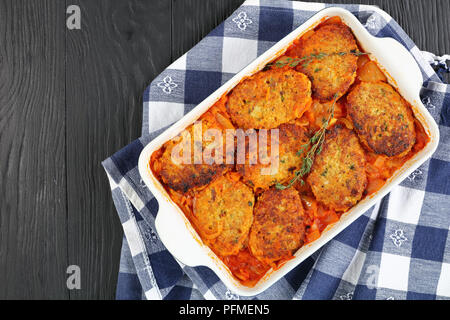 Couscous rapide et facile croquettes de poisson à l'étuvée avec l'oignon, les carottes et la sauce tomate dans le plat de cuisson, recette méditerranéenne saine, vue d'en haut Banque D'Images