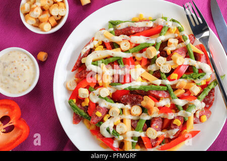 Close-up of delicious coloré hiver salade de fromage, salami, saucisses mini tranches d'asperges, maïs, poivron rouge, croûtons et sauce maison de Wh Banque D'Images
