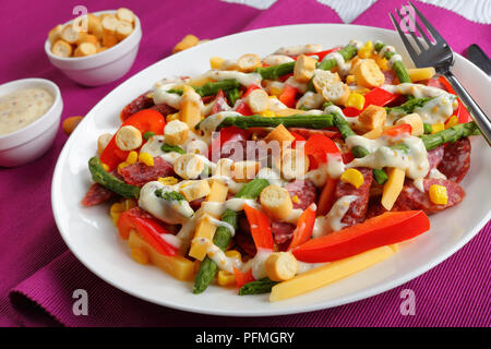Close-up of delicious coloré hiver salade de fromage, salami, saucisses mini tranches d'asperges, maïs, poivron rouge, croûtons et sauce maison de yo Banque D'Images