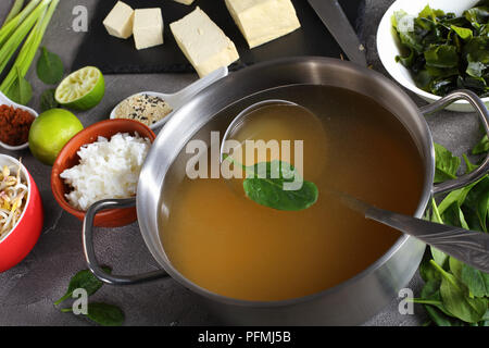 Ingrédients pour la soupe miso traditionnelle japonaise. le tofu, le dashi dans une casserole inoxydable, pâte de miso, l'algue, le riz, les champignons, les germes, les verts et des épices. Banque D'Images