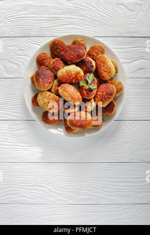 Délicieux chaud frites escalopes de viande sur plaque blanche sur tableau blanc, vertical Vue de dessus Banque D'Images