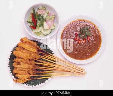 L'Indonésie, satay, brochettes de viande grillée sur tranches servi avec sauce aux arachides sucrées et salade d'accompagnement. Banque D'Images