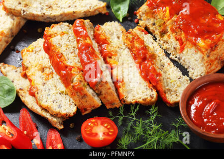 Close-up de terrine de poisson cuit juteux d'émincé de filet de poisson blanc servi avec du poivron rouge, les feuilles d'épinards, tomates cerises et sauce tomate épicée Banque D'Images