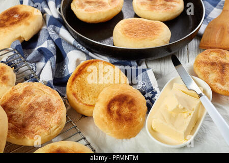 Muffins anglais chaud sur un poêle, sur une grille et cuire à muffin grillé un sandwich au beurre frais pour le petit-déjeuner, vue de dessus, close-up Banque D'Images