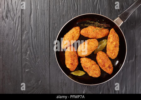 Croquettes de viande frits au fromage fondu garniture sur une poêle sur une table en bois, vue du dessus Banque D'Images