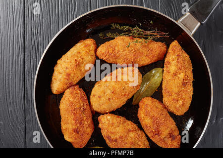 Croquettes de viande frits au fromage fondu garniture sur une poêle sur une table en bois, vue de dessus, close-up, mise à plat Banque D'Images