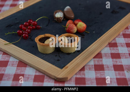 Cupcakes fraise groseille rouge sur tableau noir Banque D'Images