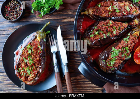 - Karniyarik, Aubergines Aubergines farcies avec du boeuf haché et de légumes cuits au four avec sauce tomate servi sur une plaque avec fourchette et couteau, Turkish cuis Banque D'Images