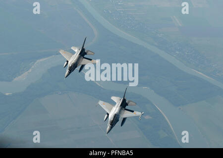 Deux F-16 Fighting Falcon roumaine voler au-dessous d'une U.S. Air Force KC-135R Stratotanker affecté à la 100e Escadre de ravitaillement en vol, Royal Air Force Mildenhall, Angleterre, au-dessus de Bucarest, Roumanie, 20 août 2018. Les États-Unis travaille en étroite collaboration avec la Roumanie sur divers problèmes mondiaux, y compris la promotion de la paix, de la sécurité et de la prospérité économique. (U.S. Photo de l'Armée de l'air par la Haute Airman Dawn M. Weber) Banque D'Images