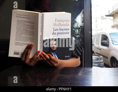 Paris, France. Août 22, 2018. Une femme lit le livre 'Les leçons du pouvoir" par l'ancien Président français François Hollande dans un café parisien. Crédit : Christian Böhmer/dpa/Alamy Live News Banque D'Images