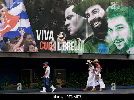 La Havane, Cuba. Août 19, 2018. Les touristes passent devant une peinture murale représentant les chefs révolutionnaires Ernesto Che Guevara (R-L), Camilo Cienfuegos et Jose Antonio Mella. Credit : Eliana Aponte//dpa/Alamy Live News Banque D'Images