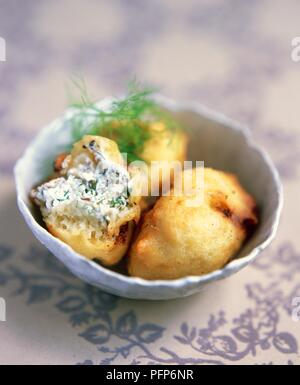 Crispeddi sicilien, beignets de semoule farci de ricotta, les anchois, les câpres et les herbes, garni de fenouil Banque D'Images