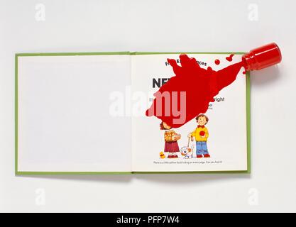 La peinture rouge s'étendre à partir de la petite bouteille sur livre ouvert Banque D'Images