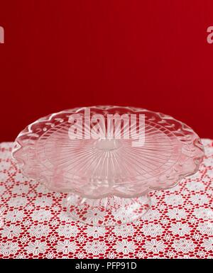 Couper le verre cakestand sur nappe en dentelle red wall set agaoinst Banque D'Images