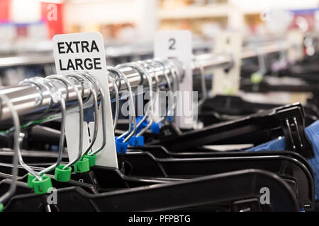 Close up d'un rack de vêtements avec très grande taille vêtements tags Banque D'Images