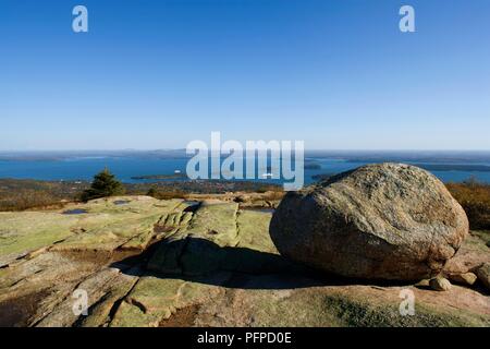 USA (Maine), Mount Desert Island, Parc National d'Acadia, Cadillac Mountain, boulder sur formatiom roche glaciaire avec vue sur Bar Harbor in distance Banque D'Images