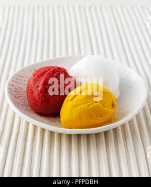 Framboise, sorbet de poire et de pêche servi dans un bol blanc sur nappe texturé Banque D'Images