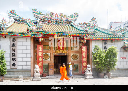 Bangkok, Thaïlande - 27 septembre 2016 : Un moine en robe orange passe devant un temple chinois. Il y a plusieurs temples de style chinois. Banque D'Images