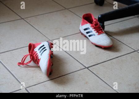 Paire de garçons ou filles football / Soccer chaussures sur le plancher. Banque D'Images
