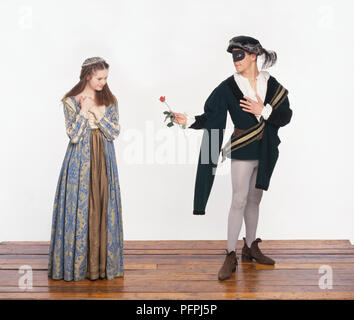 L'homme et la femme portant des costumes de l'époque de Shakespeare 16 homme, femme, rose remise à vue avant Banque D'Images
