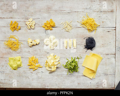 Différents types de pâtes sur fond de bois, y compris les pâtes, pâtes, pâtes ruban tubes, sur fond de bois Banque D'Images