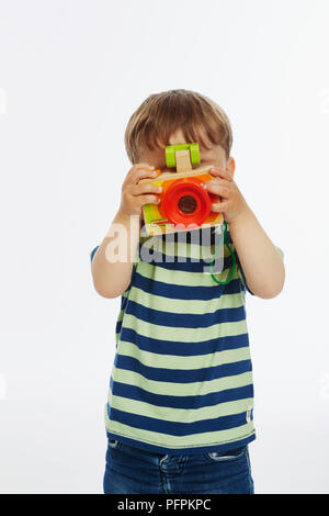 Petit garçon dans stripey haut jouant avec appareil photo (l'âge du modèle - 2 ans) Banque D'Images