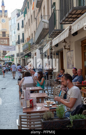 Les gens le petit-déjeuner à cafés sur Carrer de les Parellades à Sitges, Espagne Banque D'Images