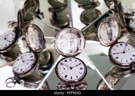 Reflet des multiples visages d'une montre de poche en argent Vintage Banque D'Images