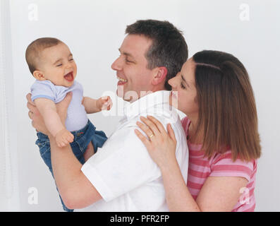 L'homme et de la femme, smiling and holding baby boy (7 mois) Banque D'Images