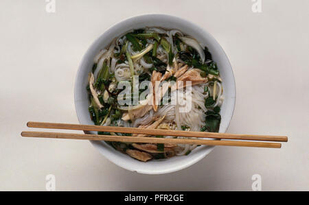 Bol de Pho vietnamien avec des baguettes sur le bord Banque D'Images